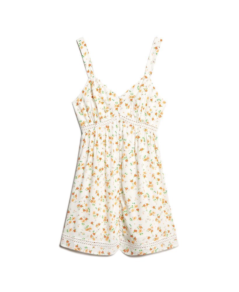 cami-jurk met v-hals en kanten afwerking in wit met een speels bloemenpatroon.