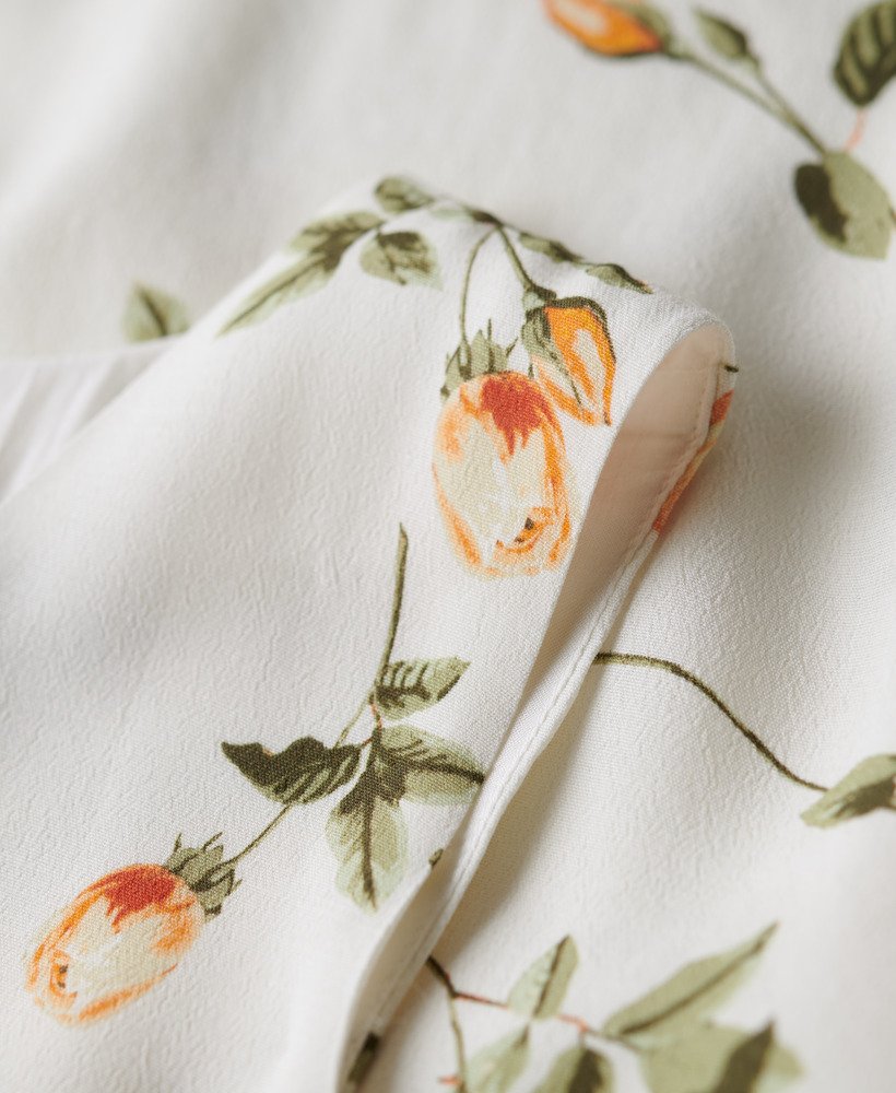 mouwloze jurk met volumineuze print in perzikroze.
