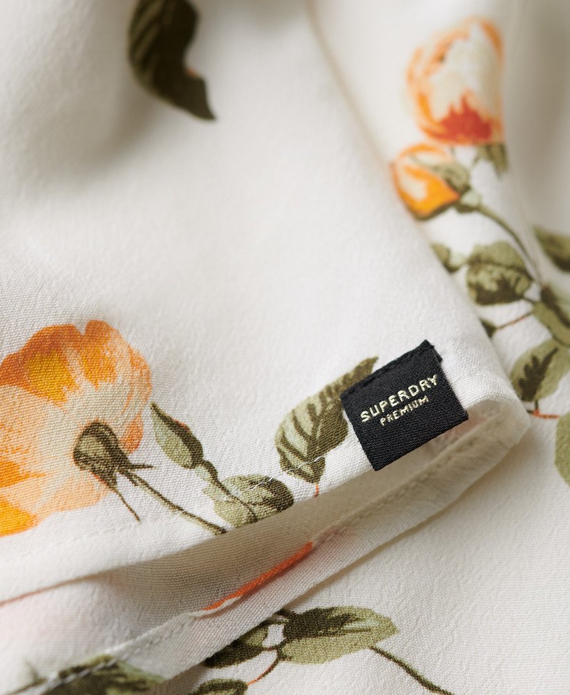 mouwloze jurk met volumineuze print in perzikroze.