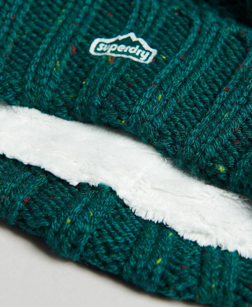 kabelgebreide muts met pompon in bosgroene tweed