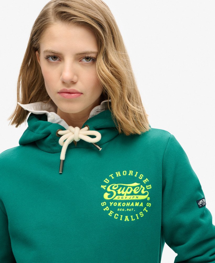 neonkleurige hoodie met geborduurde graphic in stormgroen