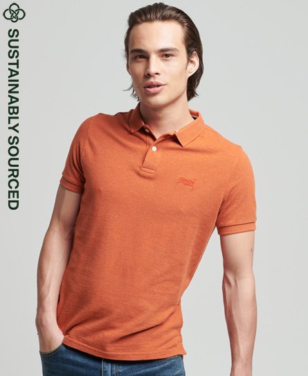 klassieke polo van biologisch katoen met piquéprint in roestbruin gemêleerde oranje kleur.